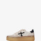 A low-top platform sneaker by Premiata, featuring a cream and beige suede and mesh upper, a black cross logo on the side, gold-tone hardware, and a thick tan gum sole.